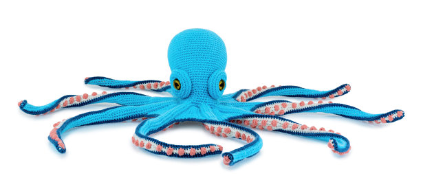 可爱的钩针章鱼娃娃孤立在白色的背景与阴影反射。顽皮的编织着蓝色的海魔鬼坐在白色的衬里。毛绒填充木偶章鱼玩具。图片下载