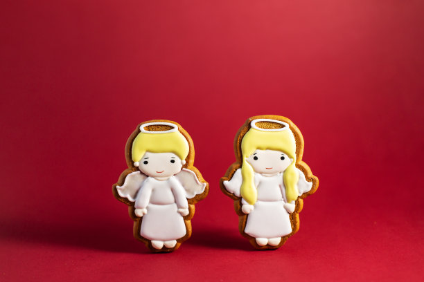 红色背景上的可爱小天使的姜饼。传统的圣诞食物。圣诞节和新年假期概念。图片下载