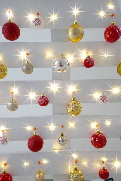 圣诞节和新年的家庭装饰。木制的白色圣诞树与红色和金色的球背景。新年冬季假期。节日的背景闪闪发光。图片下载