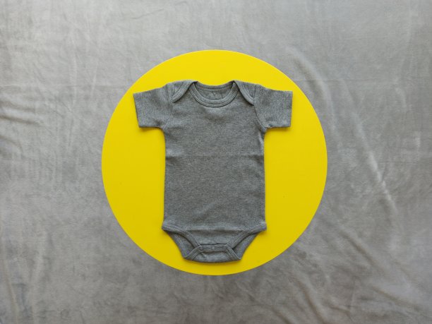 灰色婴儿连体衣在黄色的圆圈背景图片下载