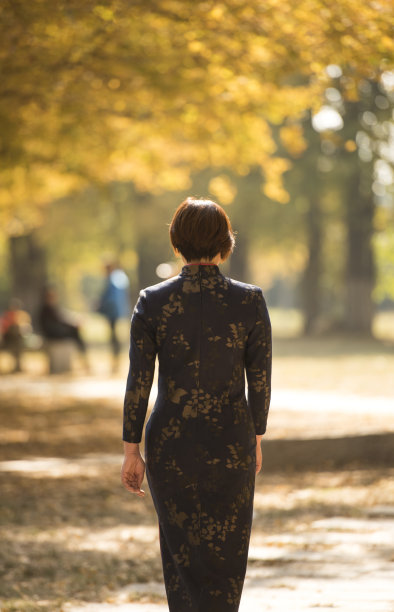 秋天走在树林里的中国妇女穿着传统的中国服装图片下载