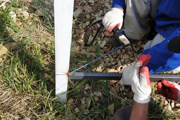 工人用焊机焊接房子周围的栅栏。图片下载