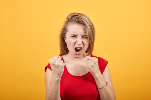 年轻的金发女孩在孤立的橙色背景红色t恤显示情绪图片下载