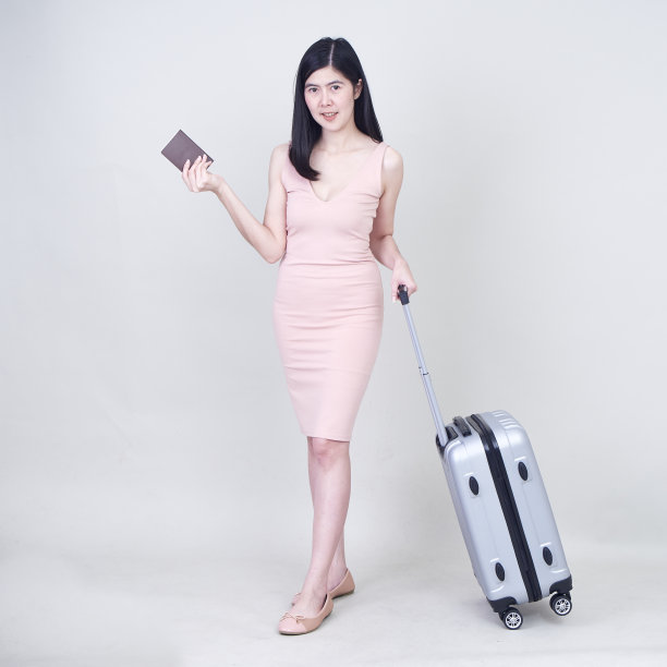 年轻快乐的女人与手提箱准备旅游的白色背景图片下载