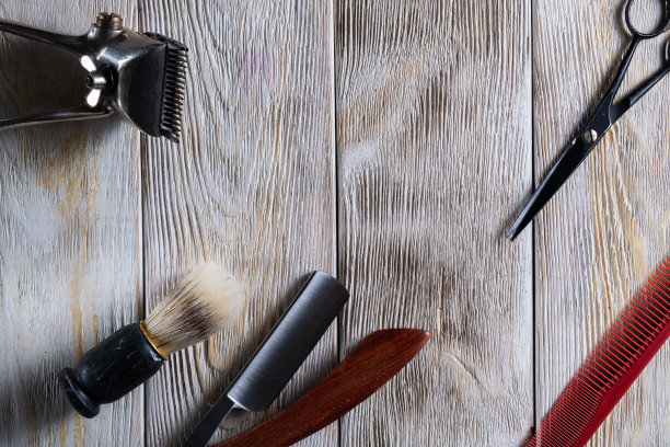 美发剪刀复古手工剪，梳子刷，危险的剃须刀都在白色风化的木质表面上。图片下载