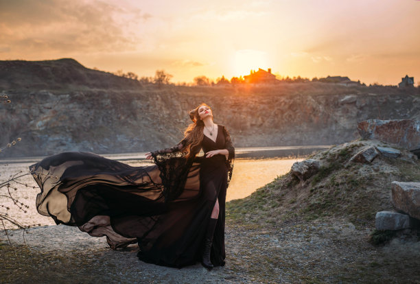 幻想中的女巫，穿着黑色飘动的丝绸长裙，头上长着犄角。黑暗的哥特式的女人图片下载