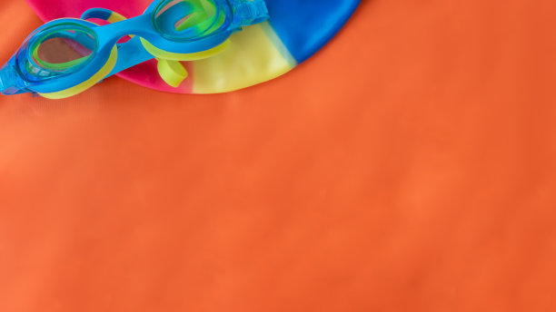 色彩斑斓的游泳装备上面有橙色的毛巾纹理图片下载