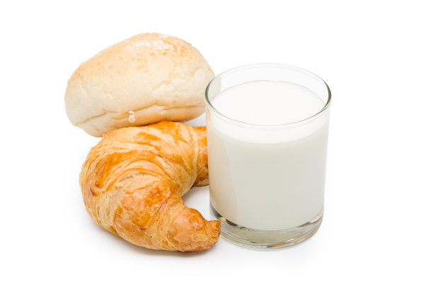 玻璃杯里的巴氏杀菌鲜奶，白色背景上有面包。图片下载