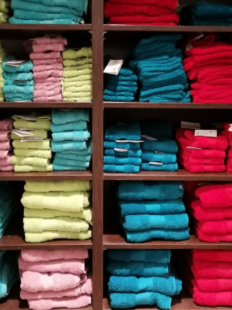 毛巾的架子上。百货商店出售彩色毛巾。浴室。淋浴。浴。图片下载