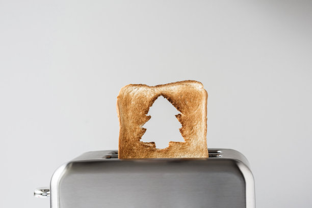 烤面包上的圣诞树洞，不锈钢复古烤面包机冒出来准备早餐。概念图片下载