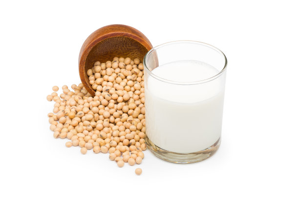 新鲜的纯豆浆与大豆在玻璃倒入一个木杯在白色的背景与剪切路径。图片下载