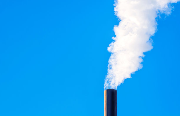 在蓝天的背景下，工业烟雾从管道中冒出来。环境污染和全球变暖的观点。图片下载