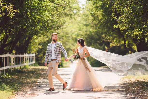 可爱的新婚夫妇木材森林。新娘和新郎，跟我来，新婚夫妇，穿着白色婚纱和面纱的女人。乡村户外爱情故事。跟随我的潮人照片。新婚夫妇手牵着手走图片下载