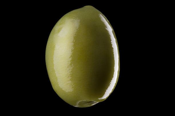 微距照片的绿色橄榄与反射光孤立在一个黑色图片下载