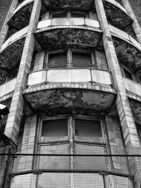 单色图像的阳台在一个旧的废弃建筑与剥落的油漆和裂纹的瓷砖图片下载