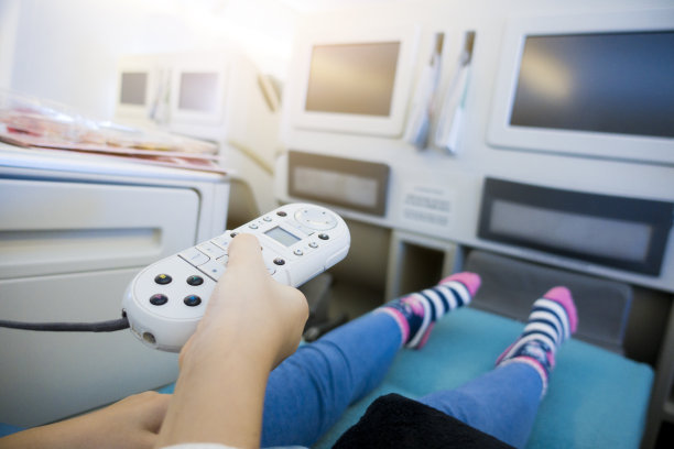 儿童手持飞行娱乐系统遥控器坐在飞机商务舱图片下载