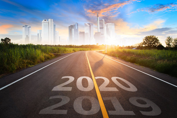 在金色的夕阳下，美丽的蓝天下，空旷的柏油路中间，写着“2020”二字。图片下载