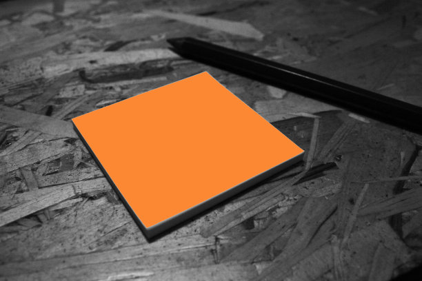 桌子上的空白橙色纸和笔图片下载