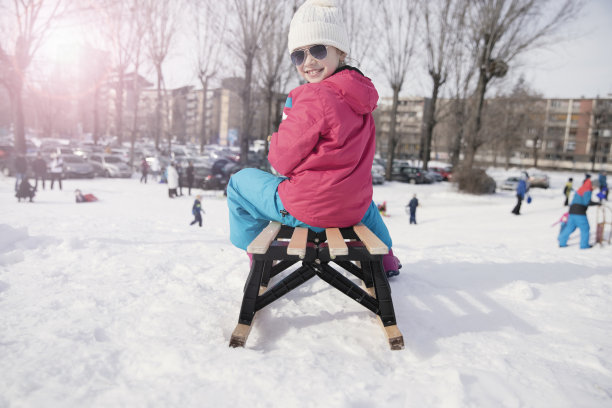 快乐的女孩坐在雪橇上图片下载