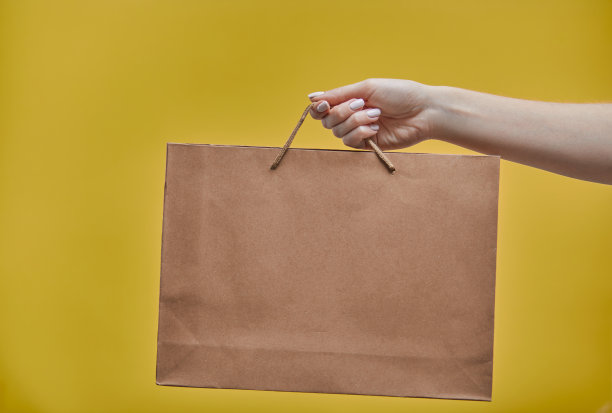 “黑色星期五”。女人手拿着购物袋在黄色的背景。促销-假日购物概念，横幅，海报，传单。图片下载