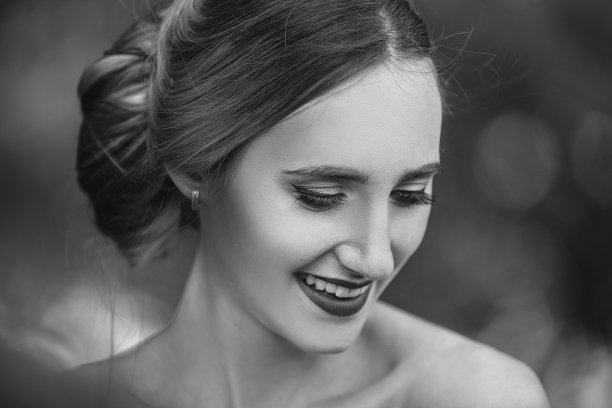 一个快乐的新娘在春天的树叶背景上的肖像图片下载