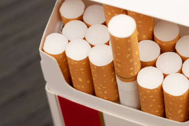 把它从烟盒上剥下来准备抽一支烟。包装线。照片滤镜自然光。图片下载