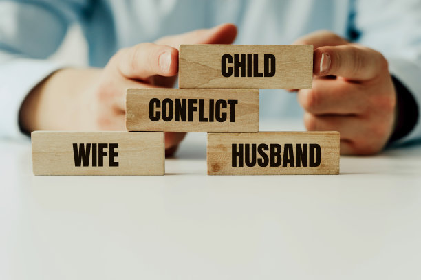 父母之间的冲突和孩子的苦难。木头拼图块上写着“妻子，丈夫和孩子”。调解人解决了父母之间的冲突。离婚与离别，分工关怀。图片下载