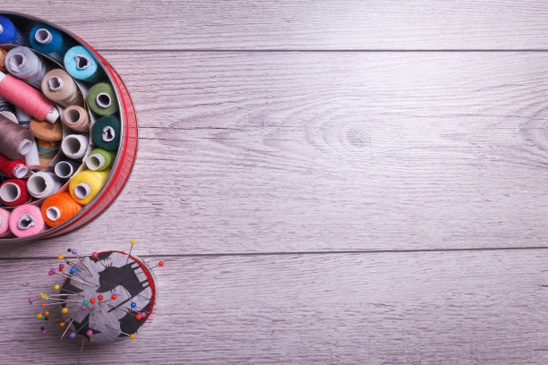 木制背景上有缝纫线和针的盒子图片下载