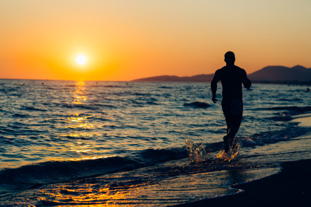 海滩上一个年轻人的剪影图片下载