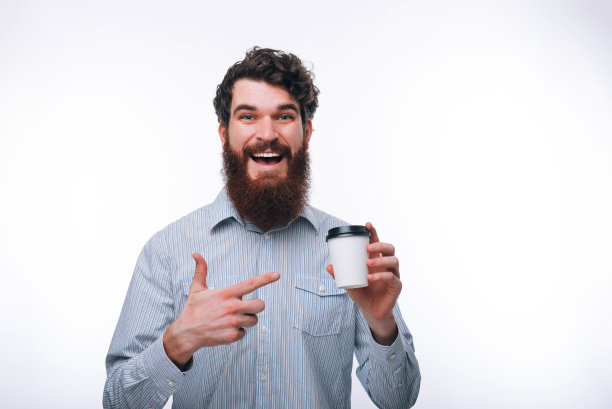照片惊讶的男子与胡子指着白色的咖啡走图片下载