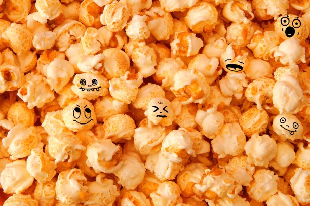 滑稽的笑脸爆米花背景。焦糖爆米花的详细特写，纹理背景。图片下载