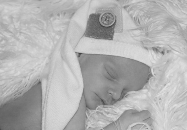 黑色和白色的新生儿睡觉，婴儿与袜子帽图片下载