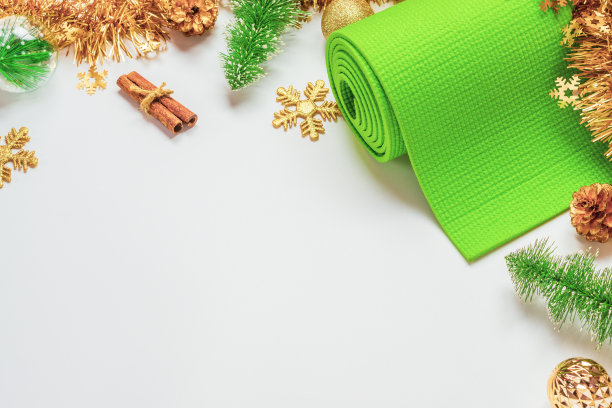 绿色瑜伽垫或普拉提垫搭配圣诞装饰。圣诞最好的礼物为健康生活方式的人概念。瑜伽圣诞和新年快乐的背景。副本的空间。图片下载