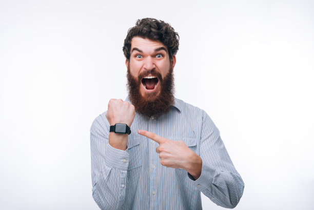 一名大胡子男子指着智能手表尖叫着图片下载