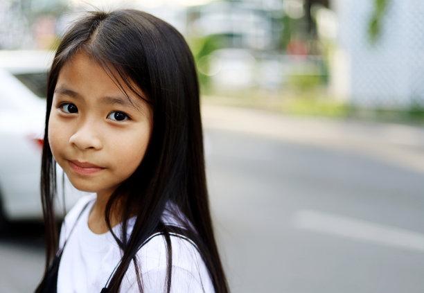 美丽的亚洲小孩女孩微笑肖像和行走旅行在步行街上的城市。图片下载