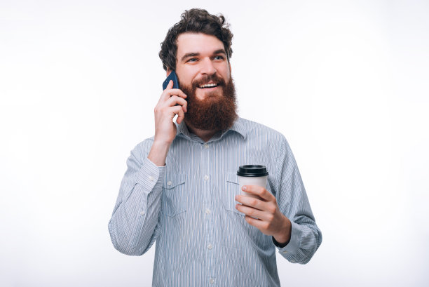 照片中的男人在打电话，拿着一杯咖啡图片下载