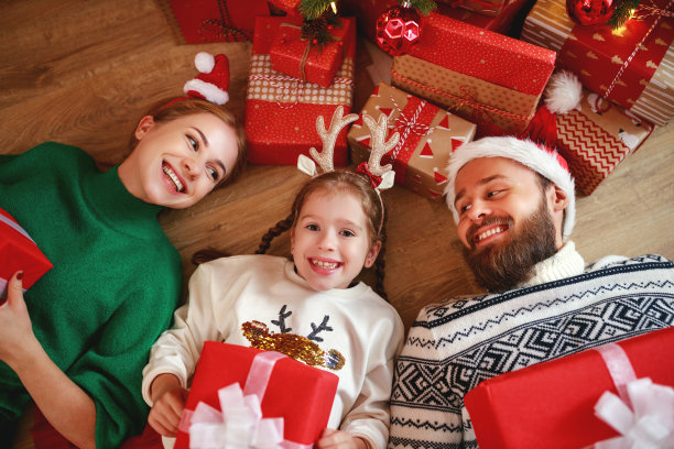 幸福的家庭妈妈，爸爸和孩子在家里的圣诞树附近的礼物图片下载