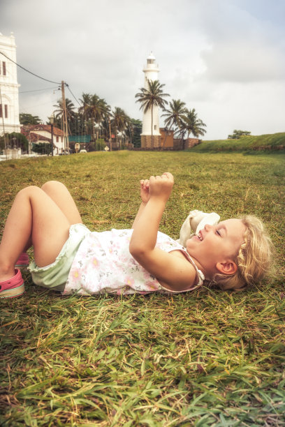 快乐的快乐的微笑的孩子女孩有乐趣躺在草地上的概念幸福快乐童年的生活方式图片下载