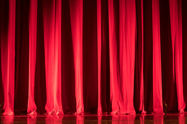 剧院的红色窗帘与聚光灯和反射地板。图片下载