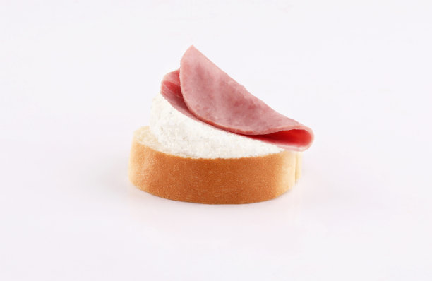 把烤牛肉和奶酪涂在面包片上，放在白色的背景上图片下载
