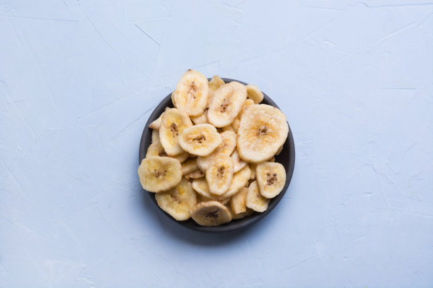 脱水，干燥的香蕉片在光的背景。从以上观点。图片下载