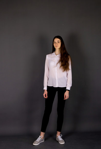 苗条的黑发女孩穿着严格的古典服装。影棚拍摄。图片下载