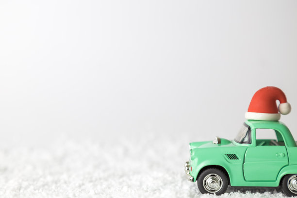 复古汽车玩具与圣诞老人的帽子在雪抽象。图片下载