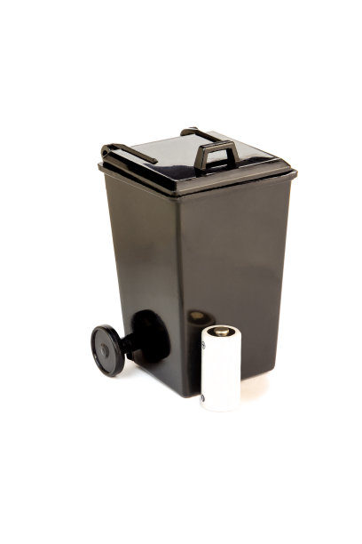 独立的黑色玩具垃圾桶旁边有废旧电池。电池回收的概念。图片下载