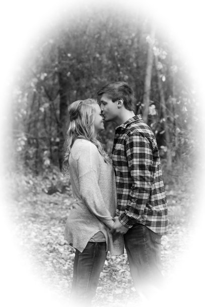 一个男人在公园里亲吻他女朋友的头顶图片下载