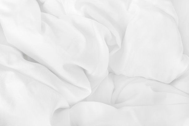 特写俯视图的白色床单和皱纹凌乱的毯子在卧室早上醒来后。图片下载