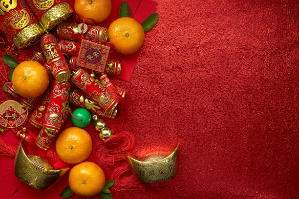 中国的硬币或中国结和中国金元宝和传统的中国结(外国文字意味着祝福)和红色的信封和装饰与新鲜的橙子在红色的背景素材图片