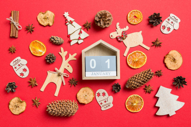 俯视图日历，红色背景装饰的节日玩具和圣诞标志驯鹿和新年树。1月1日。节日的概念图片下载