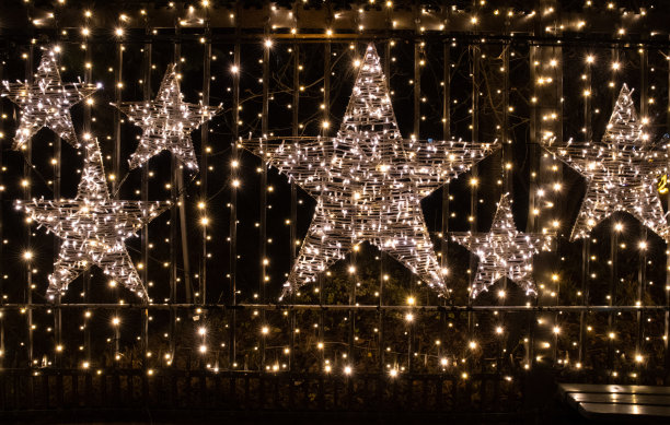 圣诞背景与闪亮的星星和闪闪发光的圣诞灯。用灯和花环装饰。抽象的背景。户外新年装饰与发光的星星图片下载