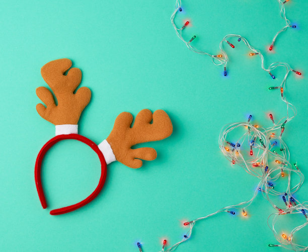 燃烧的圣诞花环在白色的电线上与五颜六色的灯和嘉年华鹿头面具图片下载